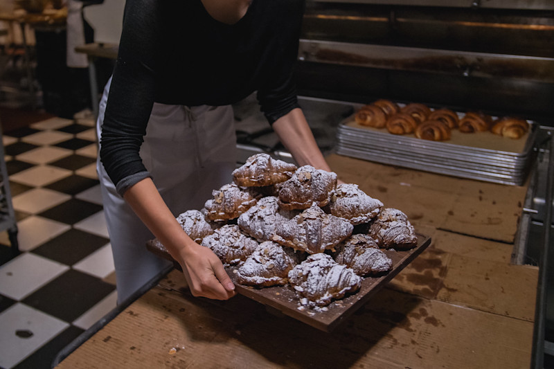 A baker loads-up a tray of pastries fresh from the oven