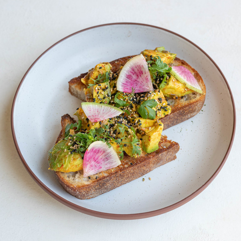 Avocado toast served with cashew salsa seca, nutritional yeast, cilantro, lime