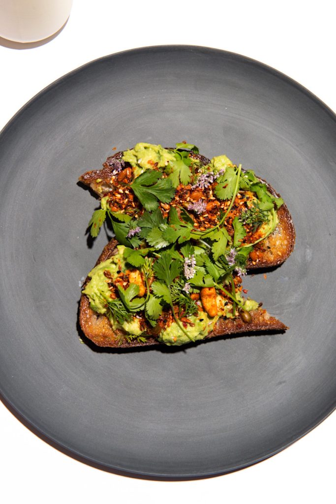 Avocado toast served with cashew salsa seca, nutritional yeast, cilantro, lime
